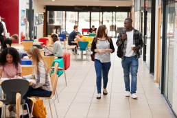 Students walking through an open plan workspace